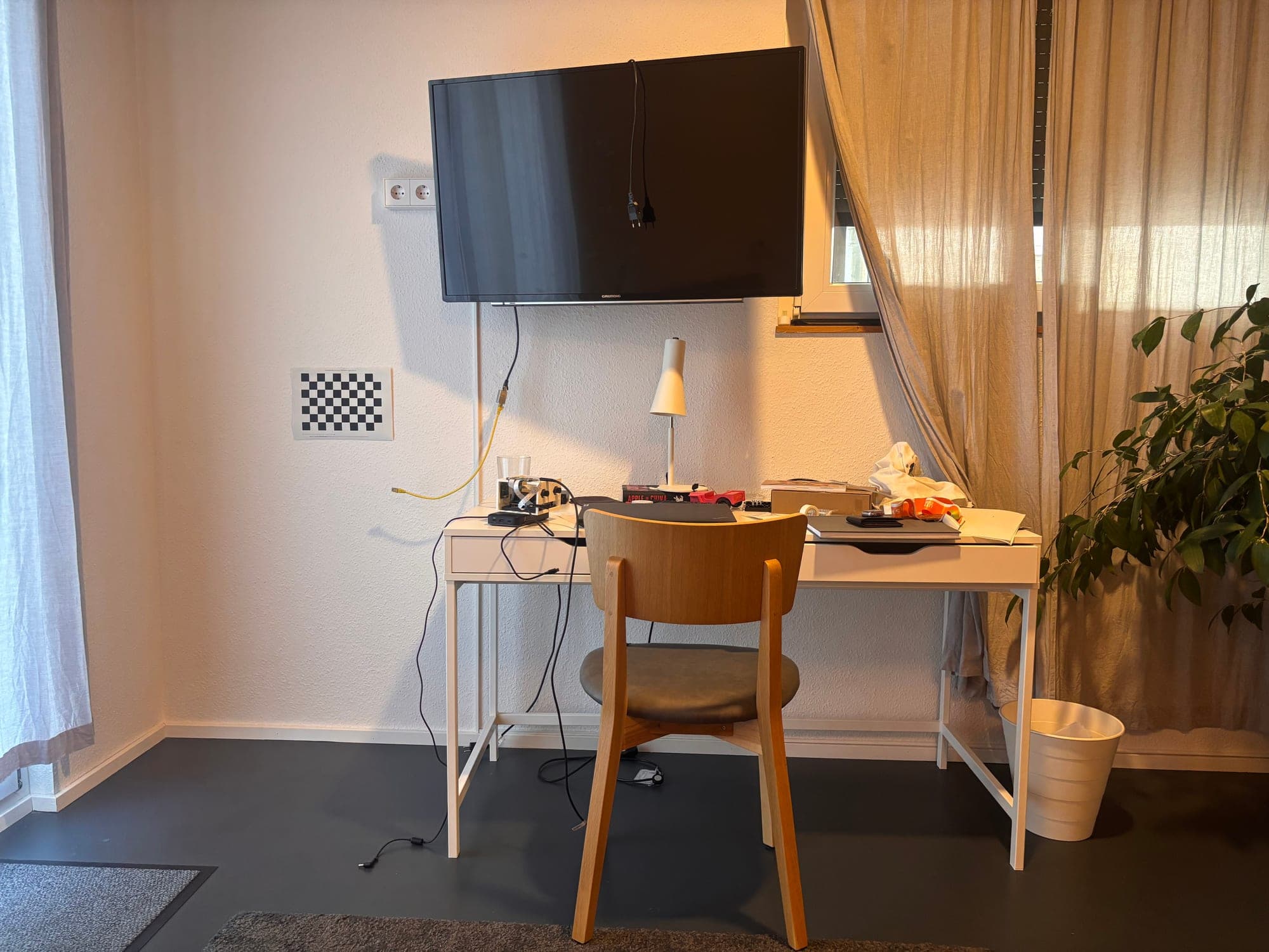 The room that was scanned: desk, wall-mounted screen, and the calibration checkerboard on the wall
